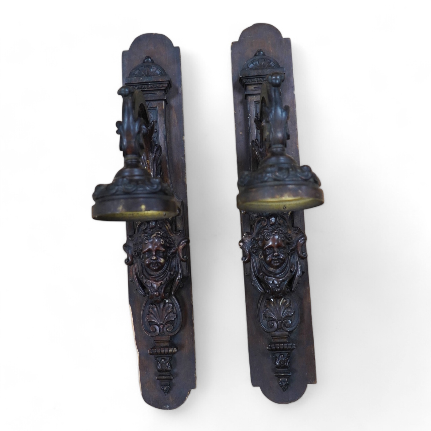 A pair of French bronze wall lights, c.1900 decorated with masks, mounted on wooden plinths, 54cm high. Condition - poor to fair